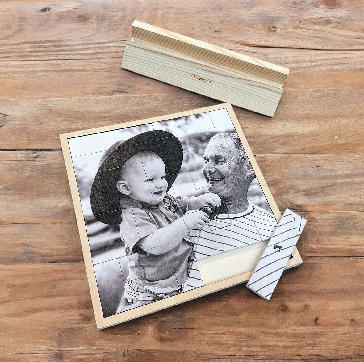 Wooden photo puzzle of a man and child on a wooden surface